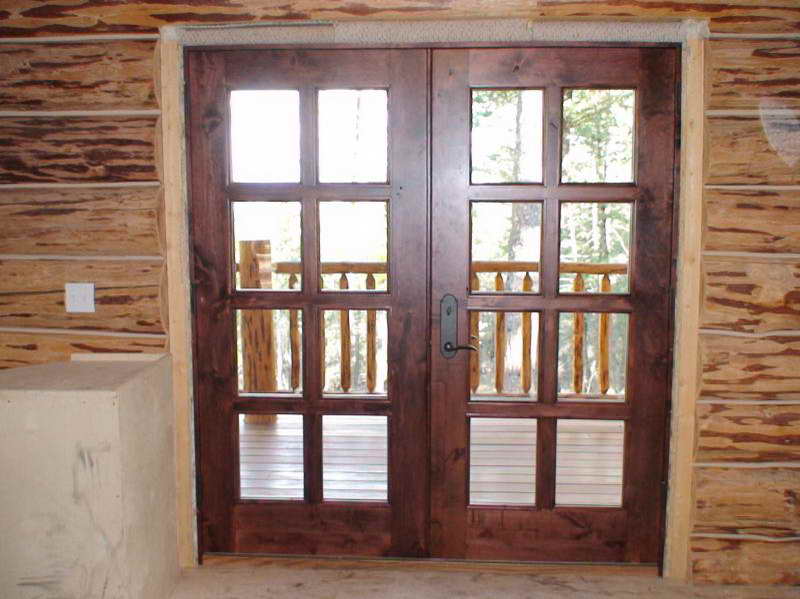 Custom wood double entry doors with glass panes in a log cabin